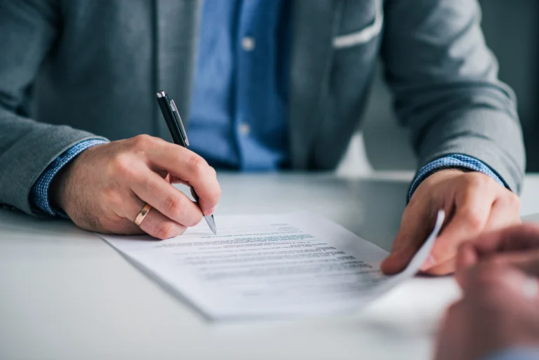 man signing a paper finance related